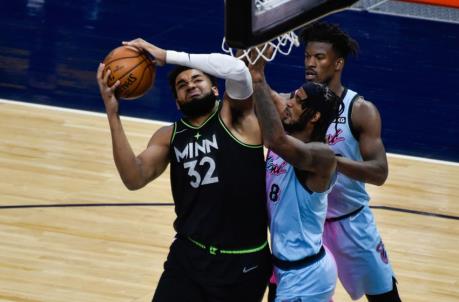 Minnesota Timberwolves center Karl-Anthony Towns (32) and Miami Heat forward Trevor Ariza (8) and forward Jimmy Butler (right) battle for the ball (Jeffrey Becker-USA TODAY Sports)