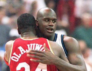 Orlando Magic center Shaquille O'Neal (R) hugs Houston Rockets center Hakeem Olajuwon (Photo credit should read CALVIN KNIGHT/AFP via Getty Images)