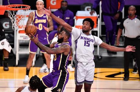 Apr 30, 2021; Los Angeles, California, USA; Los Angeles Lakers forward LeBron James (23) drives to the basket and scores past Sacramento Kings center Damian Jo<em></em>nes (15) during the first quarter at Staples Center. Mandatory Credit: Robert Hanashiro-USA TODAY Sports