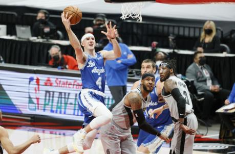 May 7, 2021; Portland, Oregon, USA; Los Angeles Lakers shooting guard Alex Caruso (4) goes to the basket past Portland Trail Blazers power forward Carmelo Anthony (bottom) during the first half at Moda Center. Mandatory Credit: Soobum Im-USA TODAY Sports