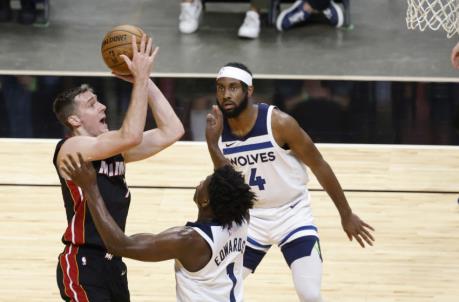 Miami Heat guard Goran Dragic (L) shoots the ball while defended by Minnesota Timberwolves guards Anthony Edwards (1) and Jaylen Nowell (4) (Rhona Wise-USA TODAY Sports)