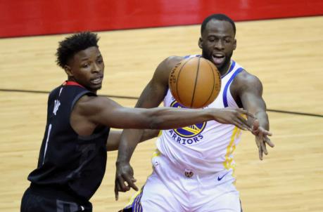 HOUSTON, TEXAS - MARCH 17: Draymond Green #23 of the Golden State Warriors dishes a pass over Jae'Sean Tate #8 of the Houston Rockets during the first quarter of a game at the Toyota Center on March 17, 2021 in Houston, Texas. NOTE TO USER: User expressly acknowledges and agrees that, by downloading and or using this photograph, User is co<em></em>nsenting to the terms and co<em></em>nditions of the Getty Images License Agreement. (Photo by Carmen Mandato/Getty Images)