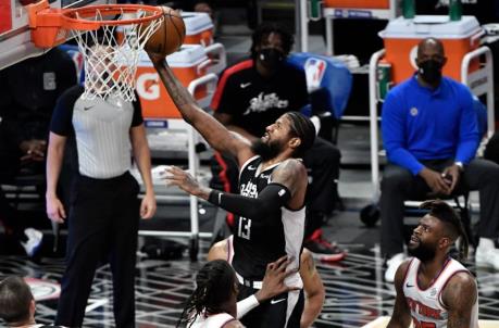 May 9, 2021; Los Angeles, California, USA; LA Clippers guard Paul George (13) flies to the basket between New York Knicks center Nerlens Noel (3), guard Derrick Rose (4) and forward Reggie Bullock (25) during the second quarter at Staples Center. Mandatory Credit: Robert Hanashiro-USA TODAY Sports