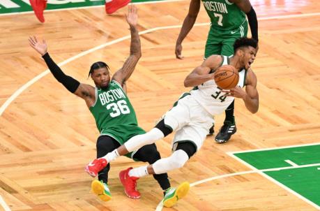 BOSTON, MASSACHUSETTS - DECEMBER 23: Giannis Antetokounmpo #34 of the Milwaukee Bucks trips over Marcus Smart #36 of the Boston Celtics during the second half at TD Garden on December 23, 2020 in Boston, Massachusetts. NOTE TO USER: User expressly acknowledges and agrees that, by downloading and/or using this photograph, user is co<em></em>nsenting to the terms and co<em></em>nditions of the Getty Images License Agreement. (Photo by Brian Fluharty-Pool/Getty Images)