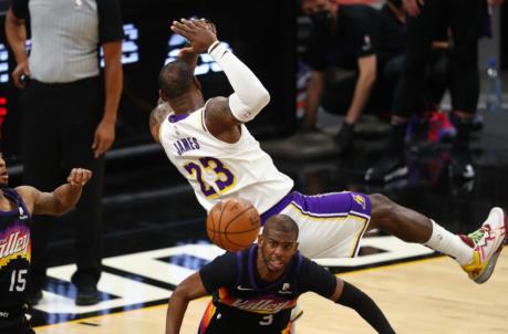 May 23, 2021; Phoenix, Arizona, USA; Los Angeles Lakers forward LeBron James (23) falls over Phoenix Suns guard Chris Paul (3) in the second half during game one in the first round of the 2021 NBA Playoffs at Phoenix Suns Arena. Mandatory Credit: Mark J. Rebilas-USA TODAY Sports