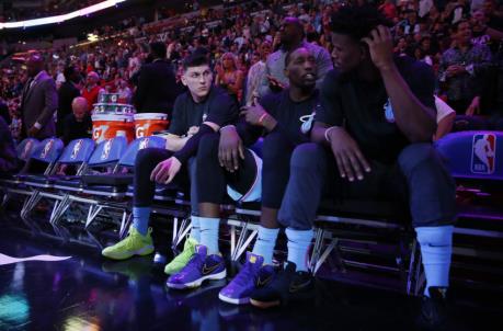 Tyler Herro #14, Bam Adebayo #13 and Jimmy Butler #22 of the Miami Heat look on prior to the game (Photo by Michael Reaves/Getty Images)