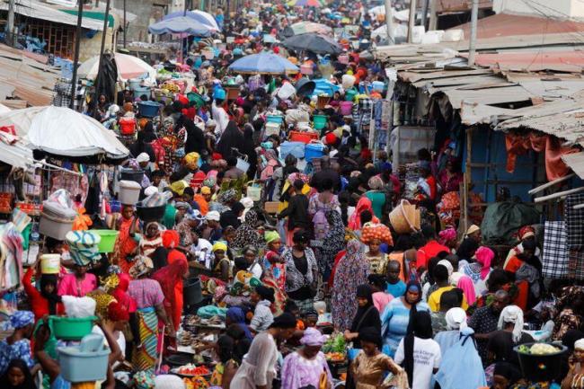 People shop at the street market ahead of the presidential election in Banjul