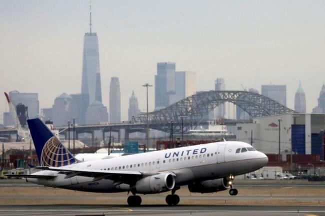 A United Airlines passenger jet takes off with New York City as a backdrop