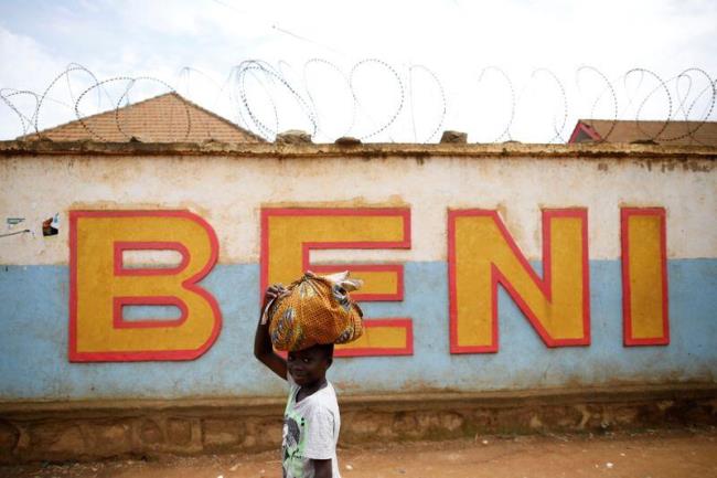 A Co<em></em>ngolese boy walks past a wall near the Alima Ebola treatment centre in Beni