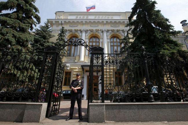 Policeman stands guard at main entrance to Bank of Russia in Moscow