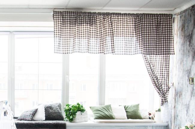 Black and white checkered valance curtain in front of bright window