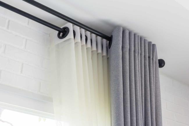 Double rod with white sheer and gray fabric curtains hanging