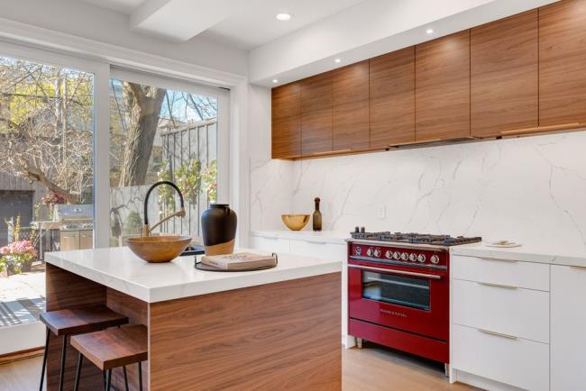 Wood kitchen with red accent stove and white marble walls