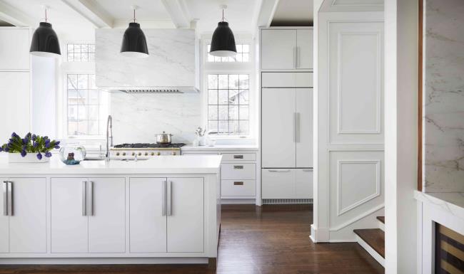 Sleek white cabinets and marble backsplash in modern kitchen