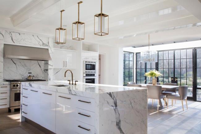 Marble waterfall countertop with storage and gold hardware