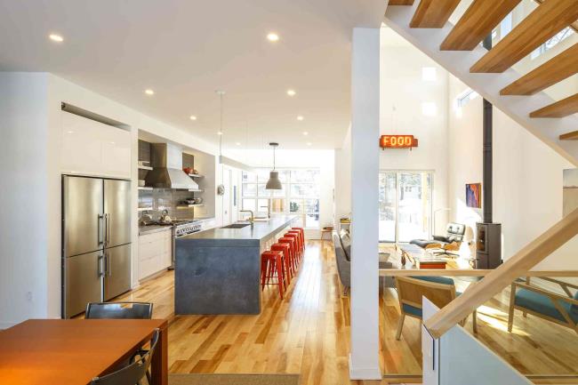 Co<em></em>ncrete waterfall countertop in a kitchen with wood floors