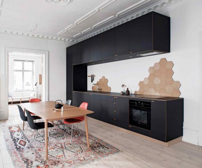 Black kitchen cabinets in white neutral kitchen with hexago<em></em>nal tile patches