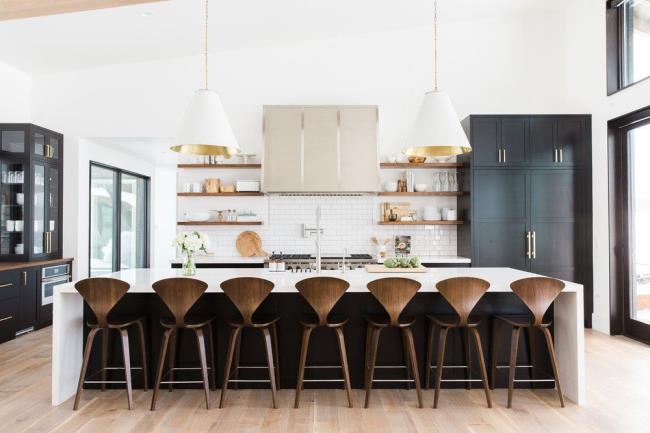 large kitchen with black cabinets and wooden bar stool chairs