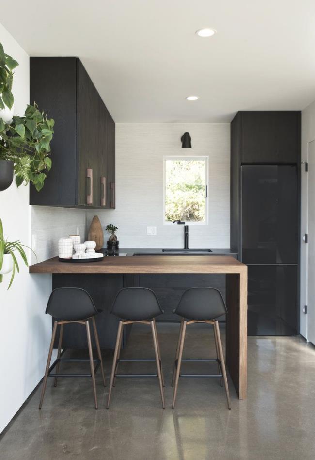 Black tile kitchen with black cabinets and silver and gold accents