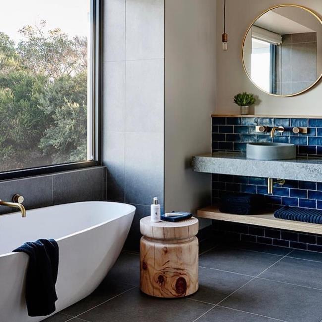 Bathroom with large white tub and cement sink