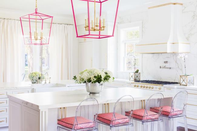 white kitchen with acrylic chairs and pink and gold accents