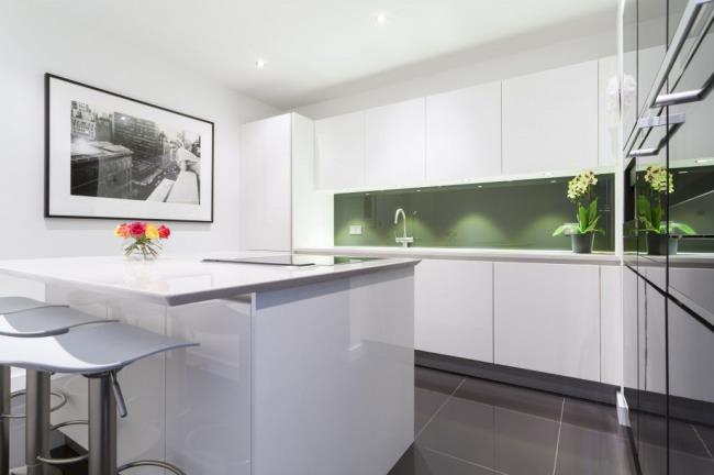 sleek lacquered white cabinets with a green backsplash