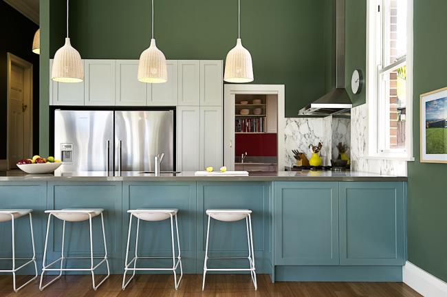 Avocado walls and blue cabinets in a kitchen.