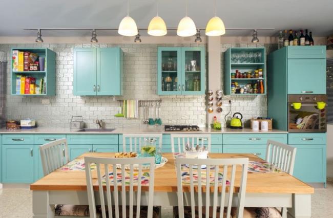 Kitchen with turquoise cabinets and butcher block kitchen table with six chairs.