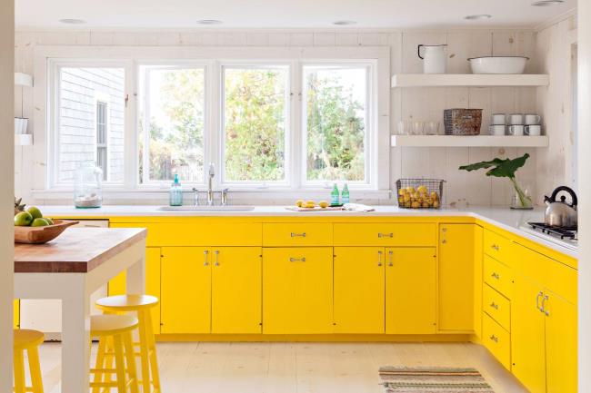 Modern farmhouse kitchen with yellow cabinets and yellow stools.