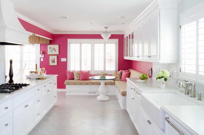 Hot pink kitchen with bright walls and white counters.