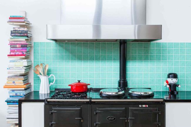 Turquoise kitchen backsplash with an arrangement of books alo<em></em>ngside the stove.