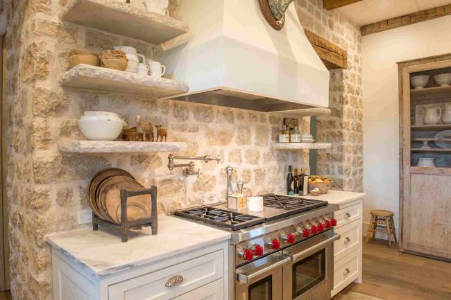 French country farmhouse kitchen with stone backsplash and floating shelves.