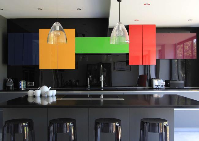 Glossy black quartz countertops with yellow, green, blue, red, and purple cabinets.