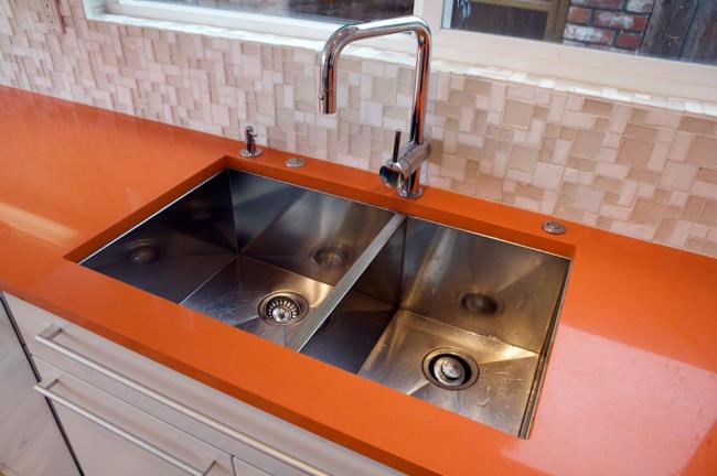 Orange quartz kitchen countertop with sink.