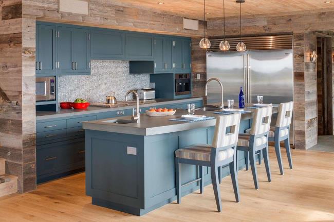 Gray countertops on a white island with black countertops and blue cabinets.