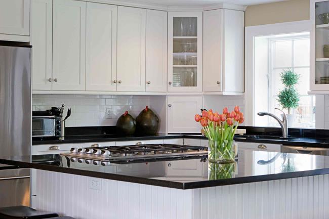 Well-lit kitchen with black granite countertop